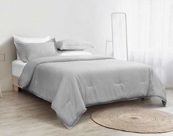 Our Heathered Jacquard Comforter Set in Grey dressed over a queen bed in a minimalist white bedroom.