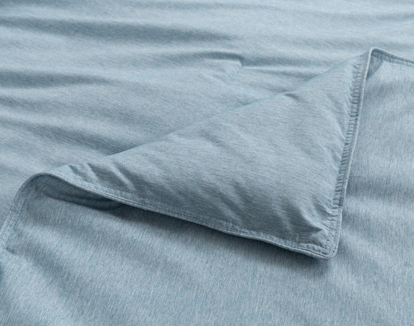 Close-up on a folded corner on our Heathered Jacquard Comforter Set in Steel Blue with its slight flanged edge.