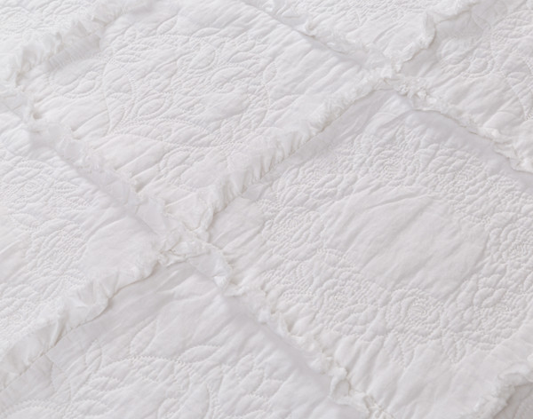 Gros plan sur les franges et la surface texturée de notre Rosalie Crib-Sized Cotton courtepointe.