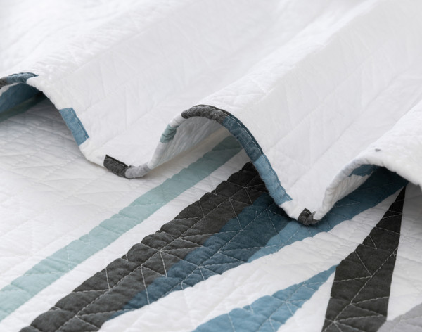 Close-up on a ruffled edge of our Zima Cotton Quilt Set to show its sensationally soft cotton surface.