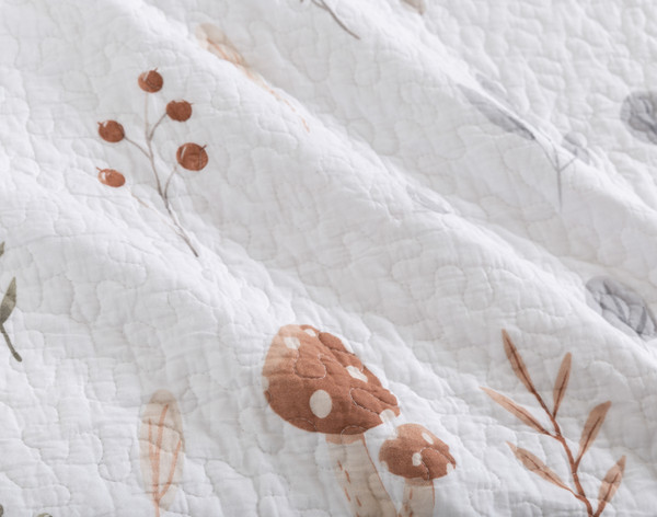 Close-up on the pattern of our Forest Floor Cotton Quilt Set to show mushrooms and branches scattered over a white background.