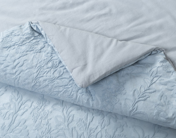 Folded corner on our Cortina Cotton Matelassé Comforter Set in Blue to show its cotton softness and filled thickness.