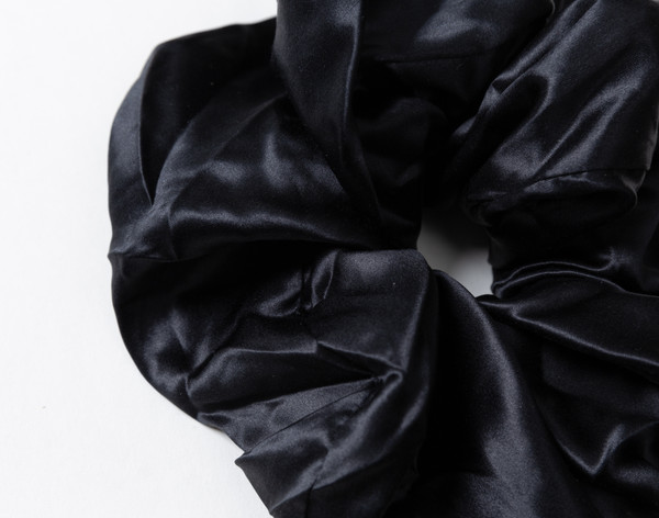 Close-up on the lustrously soft and ruffling surface on our Mulberry Silk Oversized Scrunchie in Black.