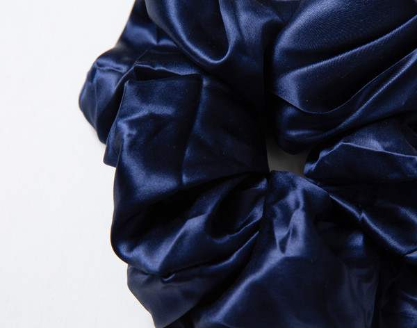 Close-up on the lustrously soft and ruffling surface on our Mulberry Silk Oversized Scrunchie in Navy.