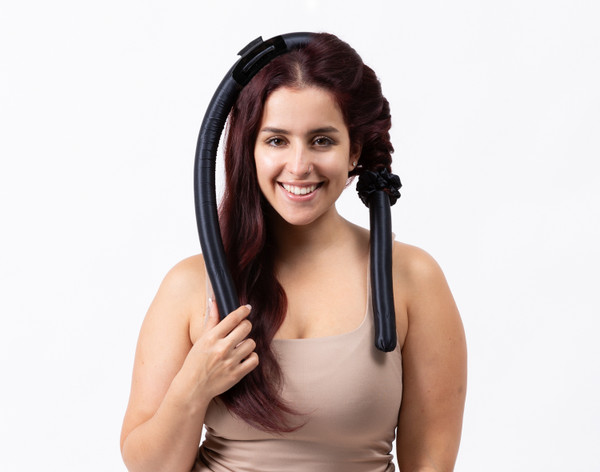 Vue de face d'une femme portant notre Silk Wrapped Heatless Curler ensemble en noir dans une pièce blanche.