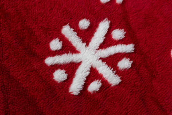 Extreme close-up on one of the unique snowflakes on our Carved Holiday Throw in Sugar Snow.