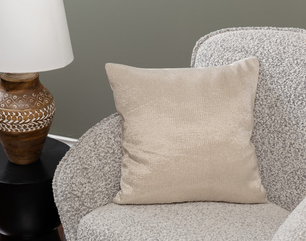 Angled view of our Beaded Square Cushion Cover in Champagne sitting in a small grey armchair in a traditional living room.