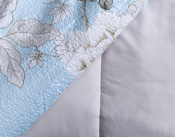 Folded edge of our Jules Comforter Set to show its patterned surface and solid reverse.