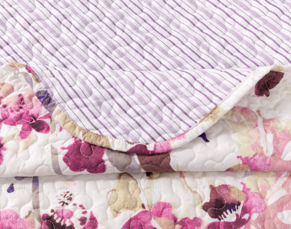 Close-up on the folded corner on our Coralia Coverlet Set to show its surface and reverse patterns together.