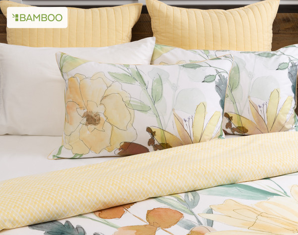 Front view of our Tilbury Pillow Sham resting against other pillows on a bed with its coordinating duvet cover.