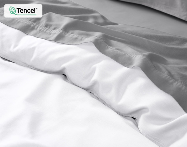 Close-up on our Hemp Touch Duvet Cover in White dressed with grey sheeting.