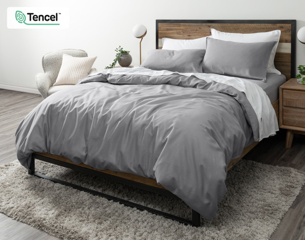 Angled view of our Hemp Touch Duvet Cover in Grey draped over a queen bed with coordinating white sheets and pillowcases.