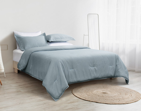 Our Heathered Jacquard Comforter Set in Teal Green dressed over a queen bed in a minimalist white bedroom.