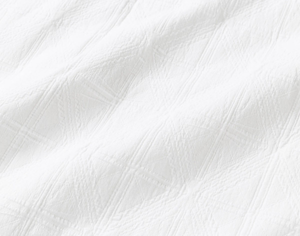 Close-up on the intricate stitching on the white cotton jacquard surface of our Shelby Quilt Set.