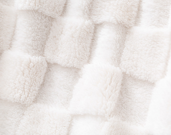 Close-up on our Checkered Teddy Throw in Natural to show its tactile checkered surface.