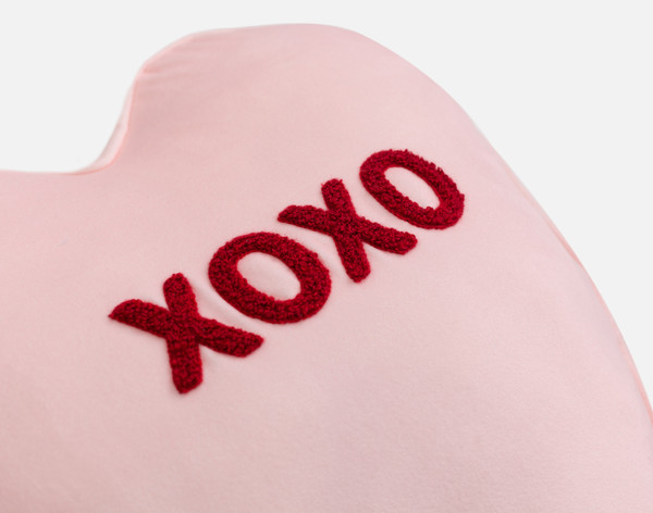 Vue en angle de notre coussin XOXO Candy Heart, nommé d'après le texte écrit en broderie tuftée en son centre.