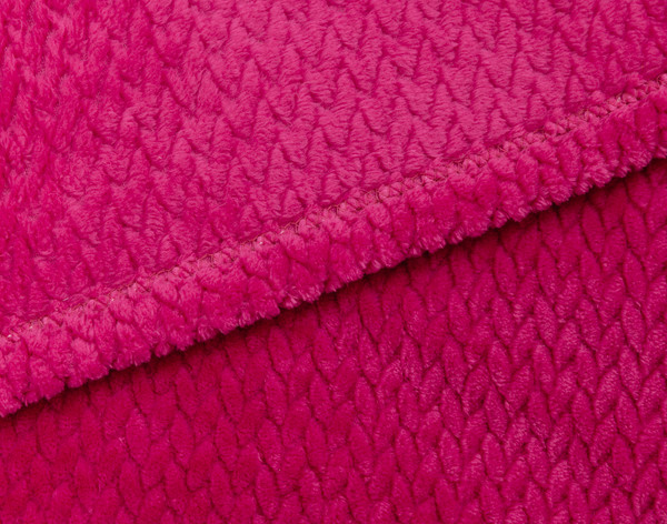 Gros plan sur la bordure ourlée de notre peluche Chevron Jeté en Fuchsia pour montrer l'envers et l'endroit ensemble.