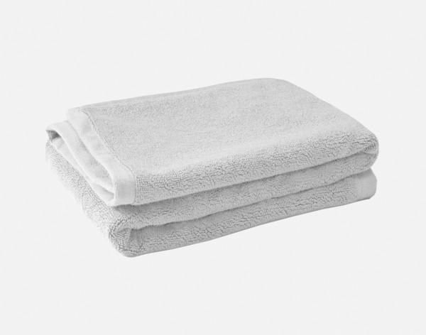 Folded pile of our Modal Cotton Bath Mat in Silver sitting against a solid white background.