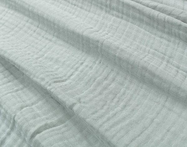 Close-up on our Seagrass Muslin Gauze Blanket to show its subtle grid-like texture and extra soft surface.