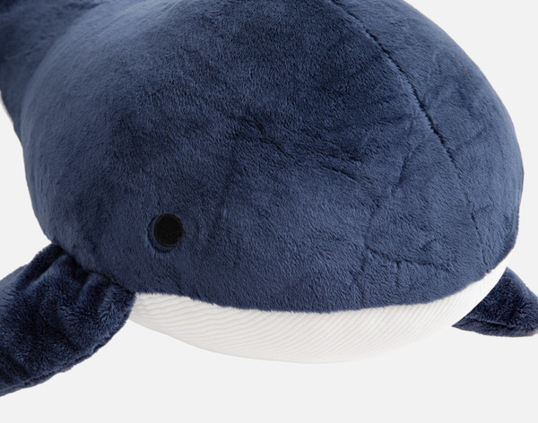 Closer view of the navy blue surface and adorably wide face on our Whale Cushion.