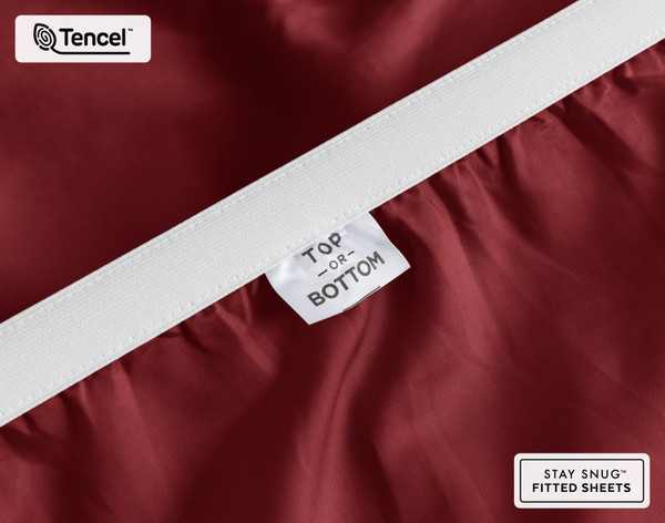 Close-up on the stretched elastic edge and tag stating "Top / Bottom" on our Eucalyptus Luxe TENCEL™ Lyocell Fitted Sheet in Black Cherry.