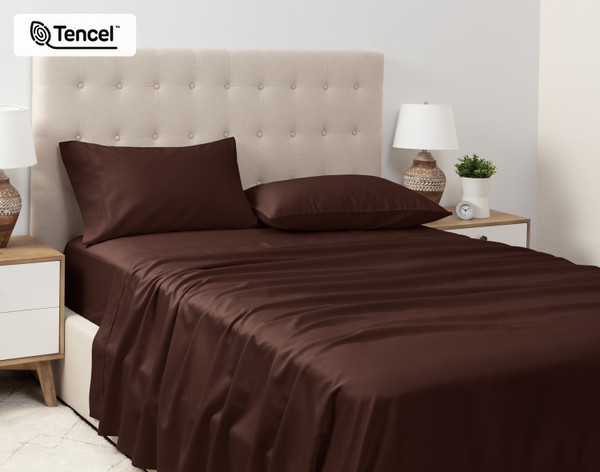 Angled view of our Eucalyptus Luxe TENCEL™ Lyocell Sheet Set in Chestnut dressed over a queen bed in a tidy white bedroom.