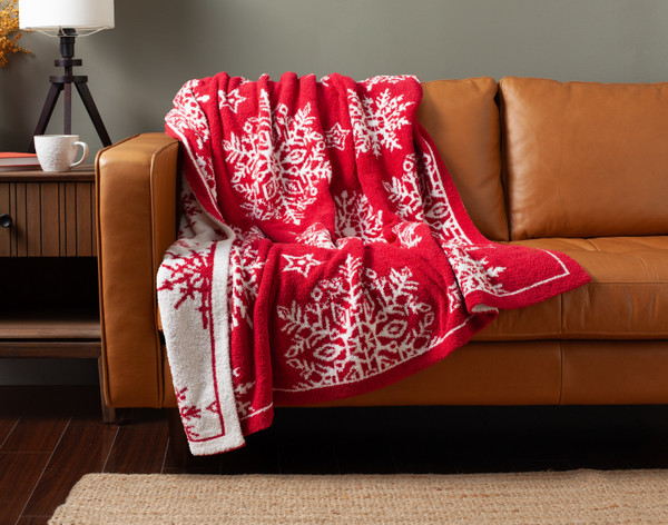 Our Snowfall Chenille Jacquard Throw draped over a brown couch.
