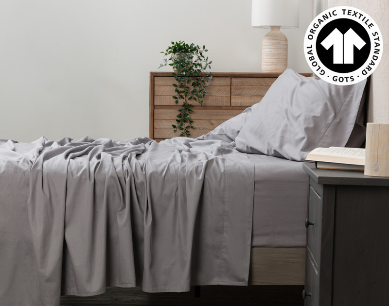 Side view of our Organic Cotton Sheet Set in Sleet to show its flat sheet draped over the side.