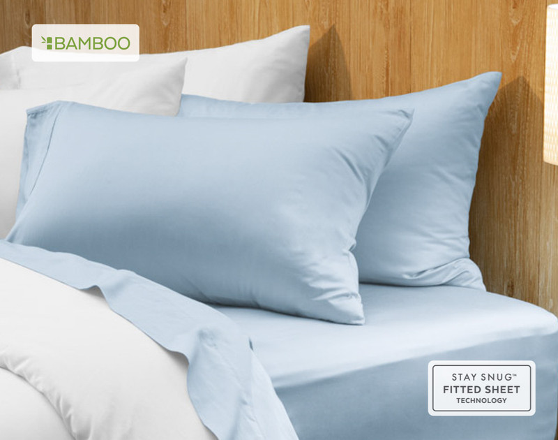 Two of our Bamboo Cotton Pillowcases in Sky Blue resting on a wooden bed with coordinating sheets.