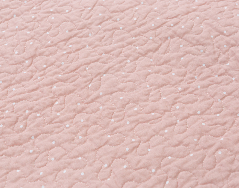 Close-up of the solid blush pink surface on our Annalise Quilt Set.