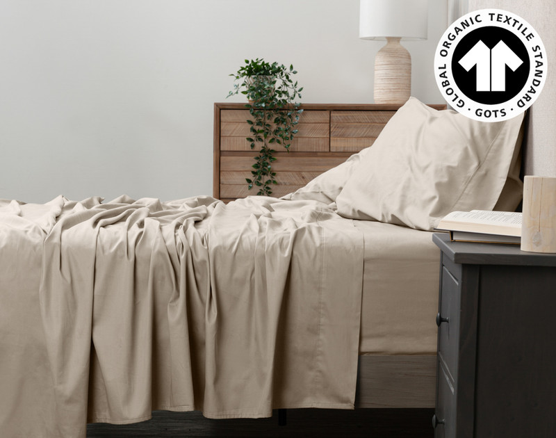 Side view of our Organic Cotton Sheet Set in Stone to show its flat sheet draped over the side.
