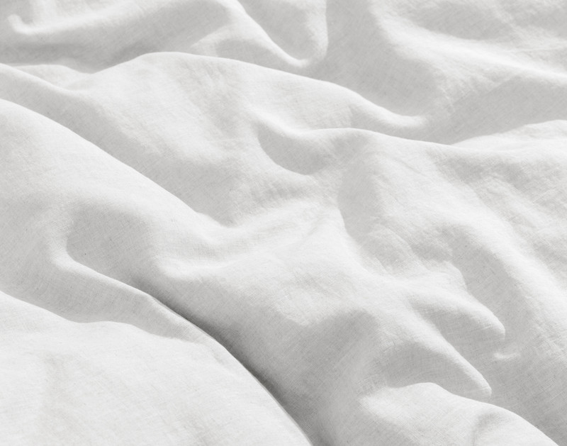 Close-up on the luxuriously soft and lightly heathered linen fabric on our Signature European Linen Duvet Cover in White.