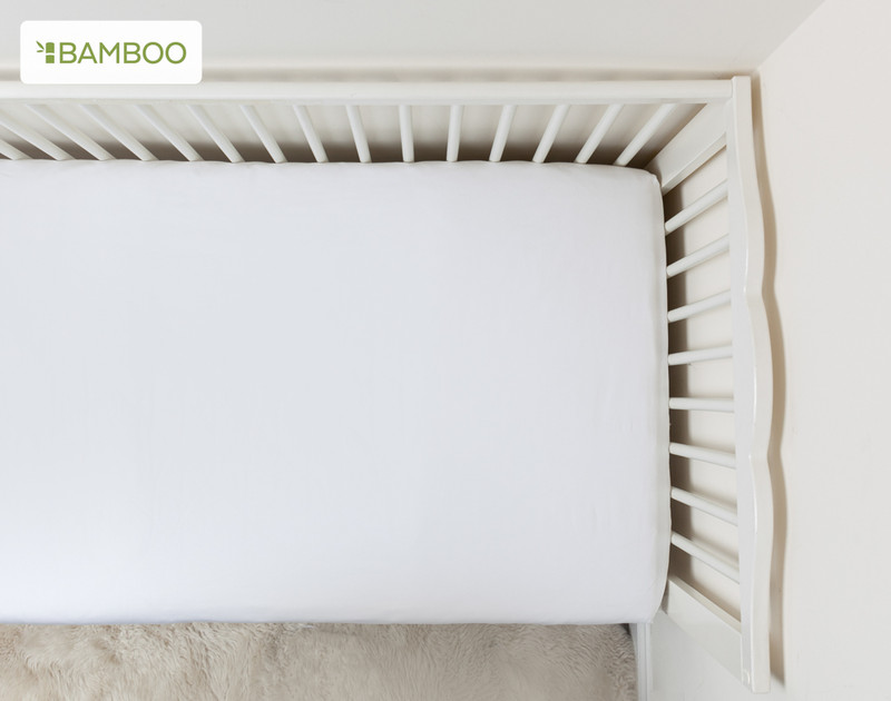 Top view of our Bamboo Cotton Crib-Sized Fitted Sheet in White to show its snug fit.