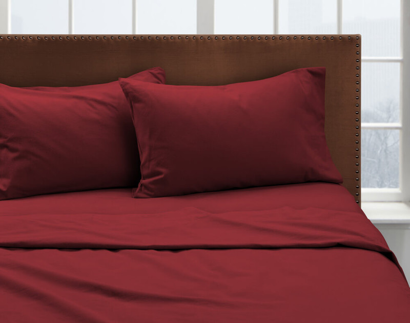 Our Rhubarb Flannel Sheet Set dressed over a bed and pair of pillows.