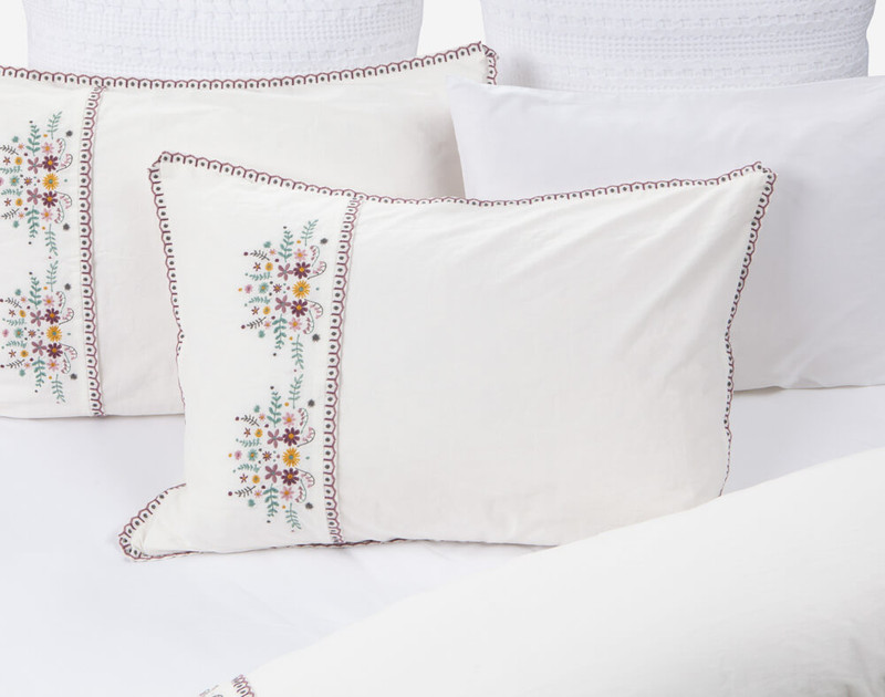 Our Kaysa Pillowcase laying on a half-open white bed.