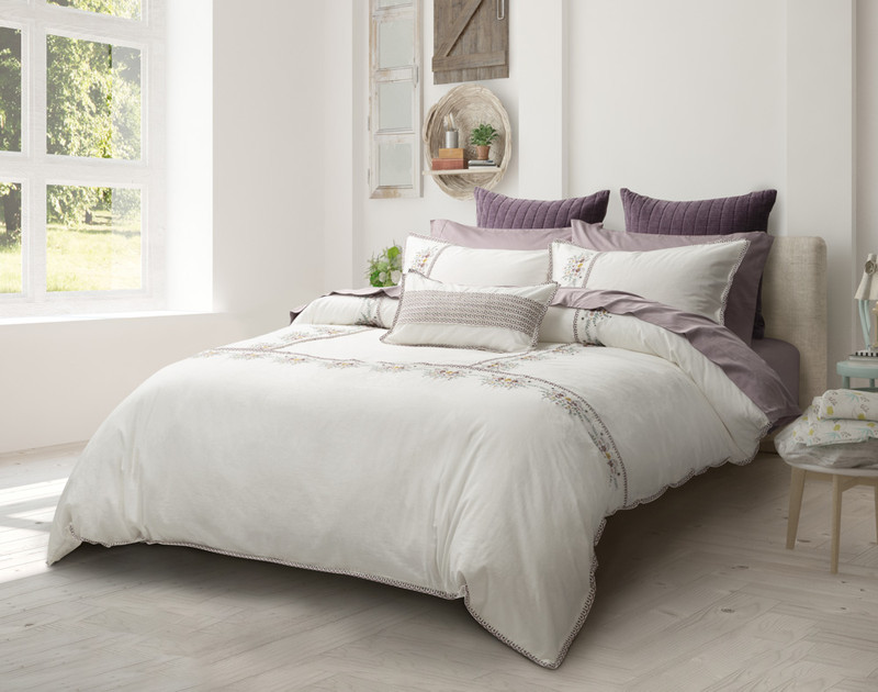 Our Kaysa Duvet Cover dressed over a bed in a white bedroom near an open, sunny window.