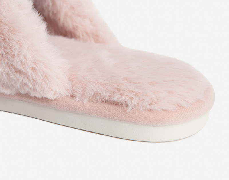 Close-up view of our Plush Faux Fur Pink Slippers in Blush on a white floor.