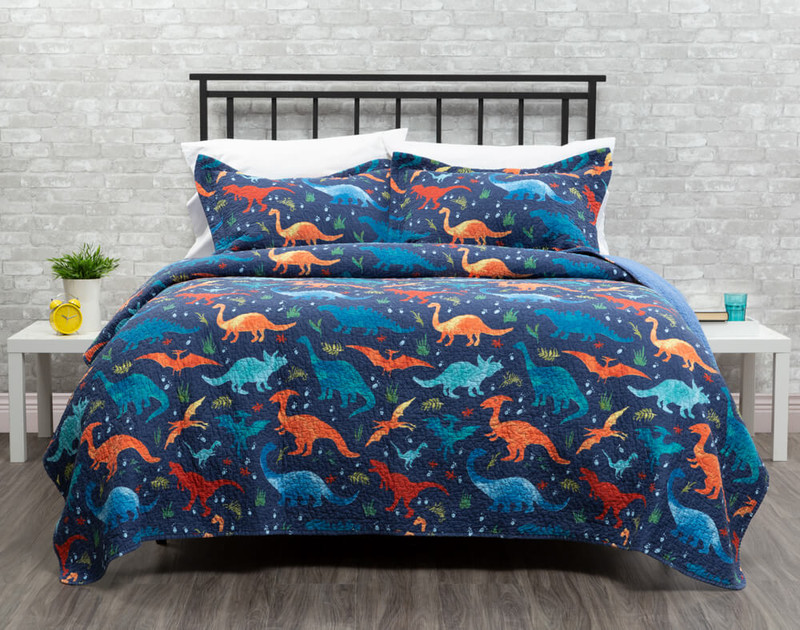Our Blue Saurus Kid's Quilt Set dressed over a bed.