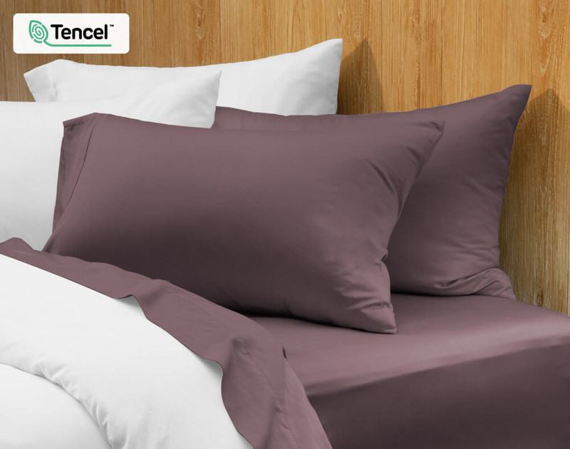 Taies d'oreiller BeechBliss TENCEL™ Modal en Inkberry, un violet sourd, sur un lit.