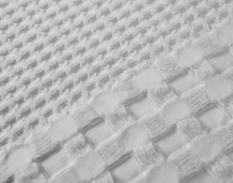 Gros plan de notre éponge Euro Sham en coton gaufré en gris pour montrer ses textures tissées mixtes.