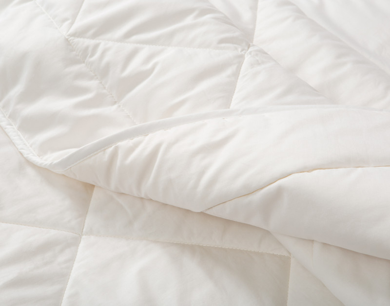 Lightly rolled side of our Affinity Australian Wool Duvet to show its flexible movement.