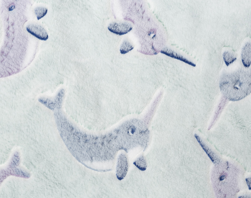 Close-up on the Narwhal pattern  on our Glow in the Dark Fleece Throw in Narwhal.