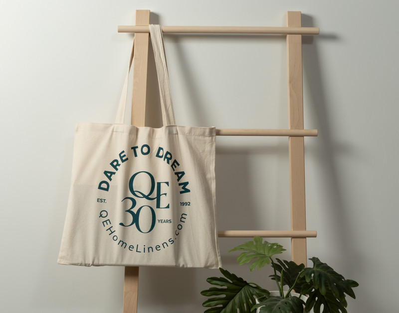 Side view of our 30th Anniversary Canvas Tote Bag in  "Dare to Dream" hanging from a ladder.