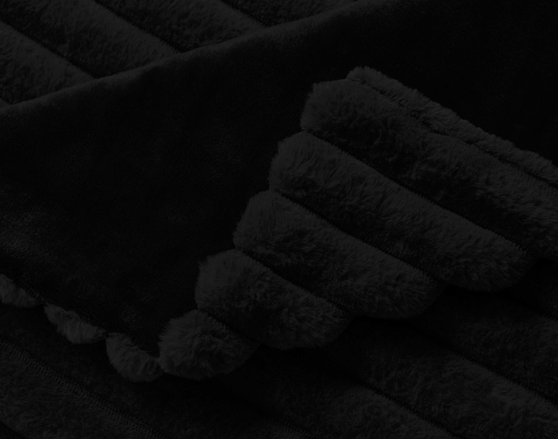 Curled corner on our Ribbed Faux Fur Throw in Black.