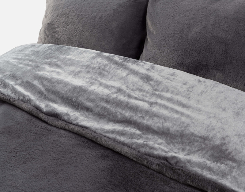 Angled view of the rolled top edge on our Puma Faux Fur Comforter Set in Charcoal to show its smooth backing and plush faux fur surface.