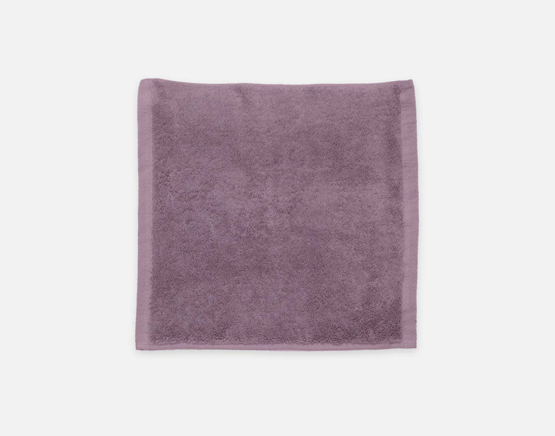 Top view of our Modal Cotton Face Towel in Lilac Ash laying flat over a solid ground.