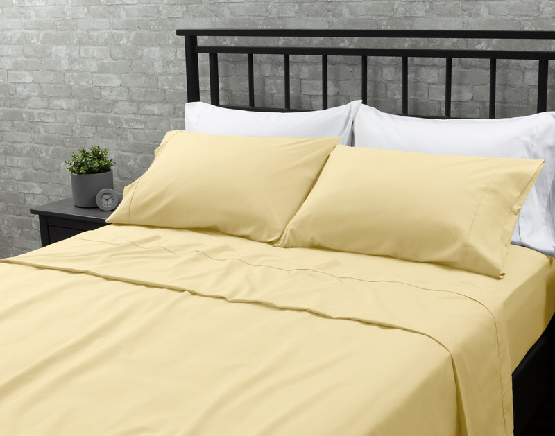 Our Cotton Percale Sheet Set in Yellow dressed over a white queen bed in a grey bedroom.