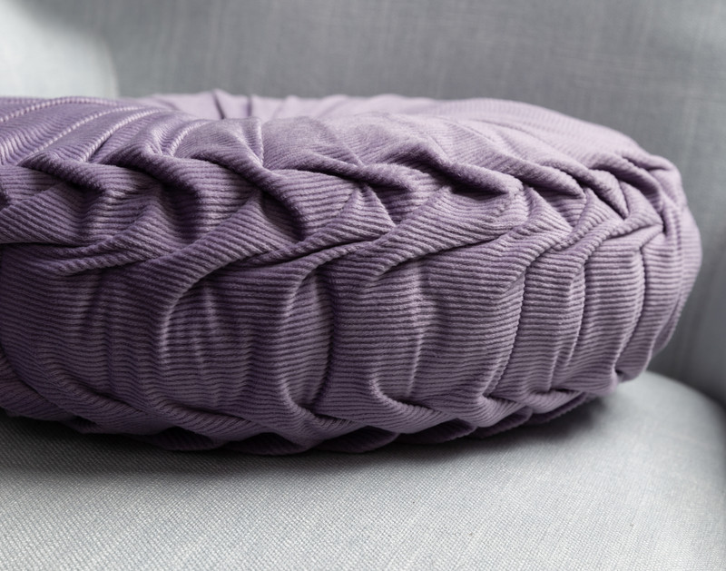 Side view of our Pin-Tuck Round Corduroy Cushion in Lavender to show its detailed pleated edge.