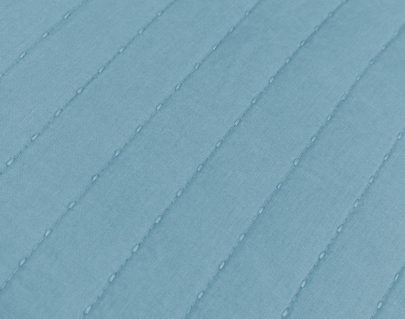 Gros plan sur les lignes matelassées texturales de l'édredon en lin et coton Lake.