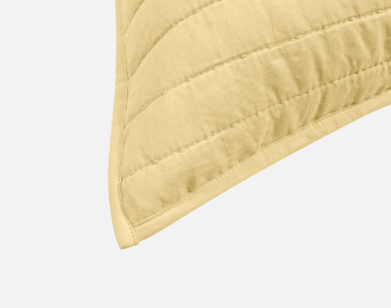 Close-up on the light flanged edge on the corner of our Linen Cotton Euro Sham in Yellow.